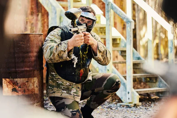 ペイントボール ターゲットトレーニングや楽しい戦場のミッションでゲームをプレイシューティングゲームで銃を持つ男性兵士 屋外の挑戦競争の生存のための軍の武器装備を持つ目的または焦点を当てた男 — ストック写真