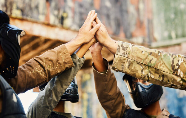 Motivation, paintball team or hands high five on a mission, friends or soldier training on war battlefield. Goals, target success or people with support in partnership or military group solidarity.