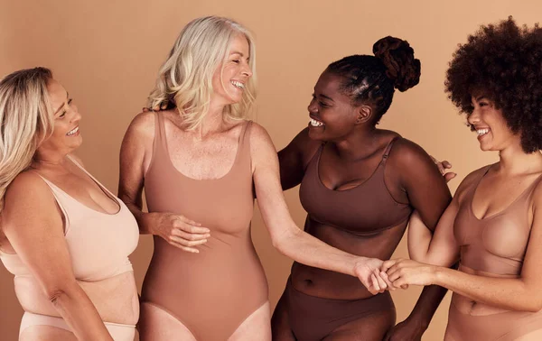 Diversity, women and skincare for body positivity, cosmetics or conversation on brown studio background. Health females and multiracial ladies with confidence, wellness or talking with smile or laugh.