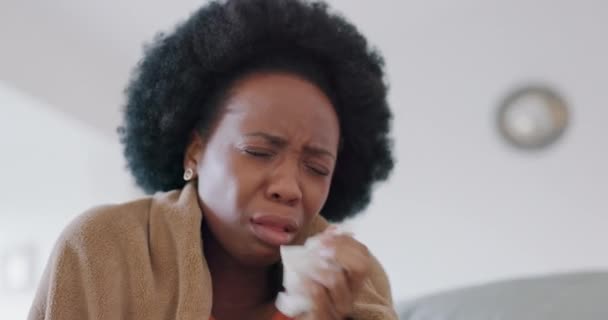 打喷嚏 过敏和生病的女人 在家里的沙发上或公寓的客厅里有软垫 非洲裔美国妇女在沙发上吹鼻涕时过敏或感染病毒 用毛毯从电晕或感冒中恢复过来 — 图库视频影像