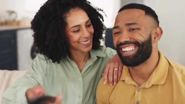 幸せな黒のカップル リラックスし 週末の笑顔でソファでテレビを見て 品質の結合時間や家での休日 アフリカ系アメリカ人のカップルは リビングルームのソファで笑顔で楽しいエンターテイメントを楽しむ — ストック動画