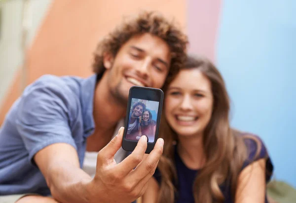 Say cheese. a young couple taking a selfie on a mobile phone