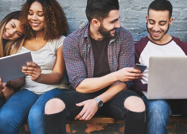 stock image Missed it online Here it is in real time. a group of young friends using their wireless devices together outdoors