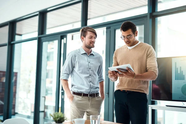 stock image Let me pull out the research I did so far...two young designers working on a digital tablet in an office