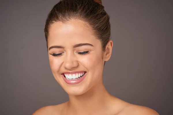 stock image Beauty is being the happiest version of yourself. Studio shot of a beautiful young woman with flawless skin posing against a gray background