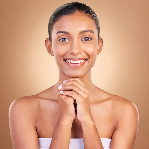 Beauty, skincare and portrait with indian woman in studio for happy, spa detox and facial. Cosmetics, self care and glow with model on brown background for satisfaction, natural makeup or confidence.