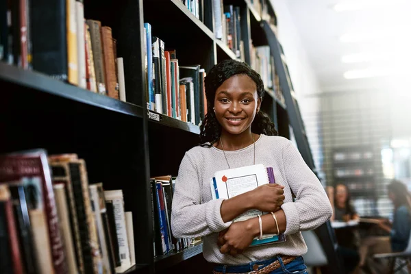 Life has a lot of lessons I want to learn. Portrait of a happy young woman carrying books in a library at college