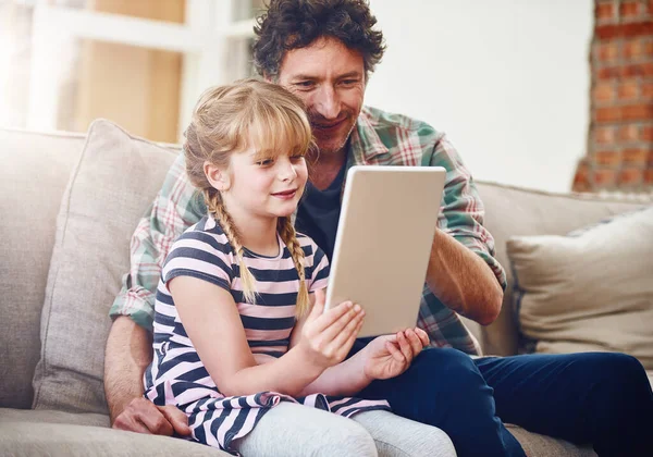 Which clip should we watch next, Dad. a father and his little daughter using a digital tablet at home