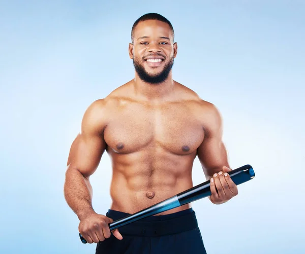 Black man, portrait and sports body with a baseball bat in studio for health, wellness and fitness. Face of healthy male aesthetic model with sport gear, strong muscle and smile on a blue background.