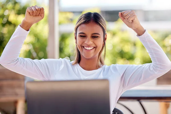 Winner, laptop and cheering with a freelance woman remote working from a cafe on her small business startup. Wow, motivation or celebration with an attractive young female entrepreneur at work online.