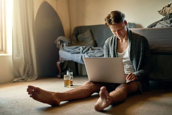 お気に入りのサイトをサーフィン 自宅でノートパソコンを使っている青年が — ストック写真