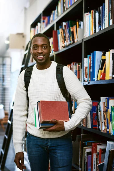 本を打つ時間だ 大学の図書館に本を持っている幸せな若い男の肖像画 — ストック写真
