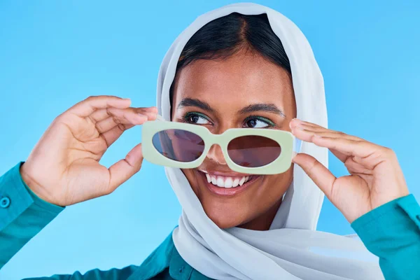 ヒジャーブ デザイナーブランドの眼鏡やカジュアルな服装スタイルでファッションサングラス 顔や幸せなイスラム教徒の女性 Gen Z夏の美学 イスラムモデルの笑顔と青の背景スタジオでのアラビア語のイスラム女性 — ストック写真