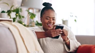 Siyah kadın, telefon ve mesajlaşma sosyal medya, uygulama ya da internet mesajı olan bir kanepede. İnternet, meme ve kadın oturma odasında okurken, gezinirken ve aboneliğin keyfini çıkarırken dinleniyor.