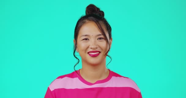 亚洲女人笑着 在一个绿松石背景的与世隔绝的空间里 在工作室里为滑稽的迷因而面对着肖像 拥有美丽 化妆品和积极的色彩气质的快乐女性模特 — 图库视频影像