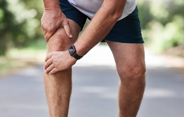 膝盖疼痛和老人手牵着腿在公园里进行室外健身和锻炼 健康和肌肉紧张 老年跑步者受伤 双手扶手疼痛或缓解 — 图库照片