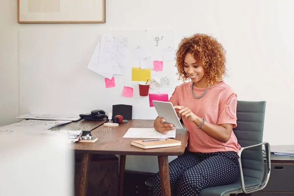 stock image Design goes digital. a happy young designer using her tablet while sitting at her desk in the office