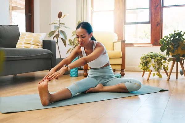 Home, fitness or woman in yoga stretching legs for body flexibility, wellness or healthy lifestyle. Feet, calm or active zen girl in exercise, workout or training warm up in house exercising studio.