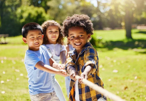 夏に公園や遊び場で一緒に屋外で綱引きをしている楽しさ ゲーム 子供たち 晴れた日に庭で遊んだり絆を深めたりしながらロープを引く友人 多様性と子供たち — ストック写真