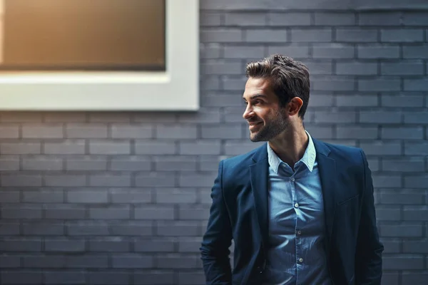 stock image Success waits for no one. a handsome young businessman standing against a grey facebrick wall