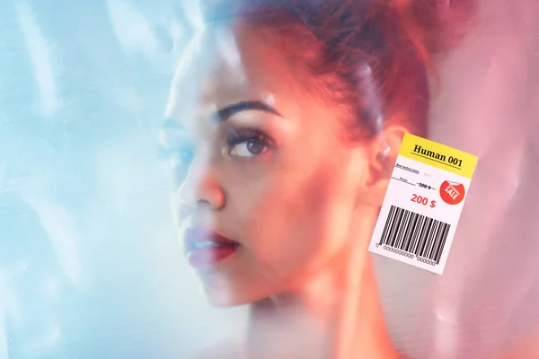 stock image Portrait, plastic and woman in studio with human trafficking label package with barcode sale sign. Face, aesthetic and girl packaging for concept, abstract or creative model posing for conceptual art.