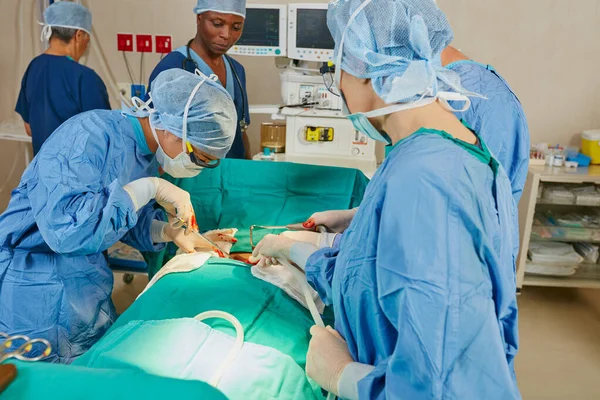 致力于拯救生命 在手术室里做手术的一组外科医生 — 图库照片
