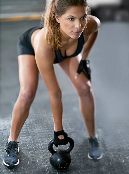 努力训练以获得她想要的结果 一个年轻的女人在健身房用水壶的铃铛锻炼身体 — 图库照片