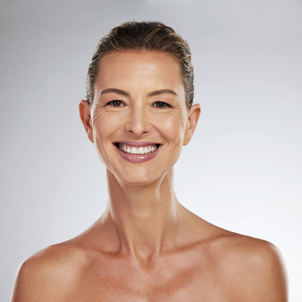 Happy, beauty and skincare face of woman with skin health, wellness and cosmetic against a grey studio background. Portrait for mature female with healthy anti aging healthcare, makeup and cosmetics.