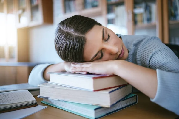Sleeping, tired and fatigue student with books studying for university exam, learning and knowledge in a library or education workspace. English, literature college woman burnout with school research.