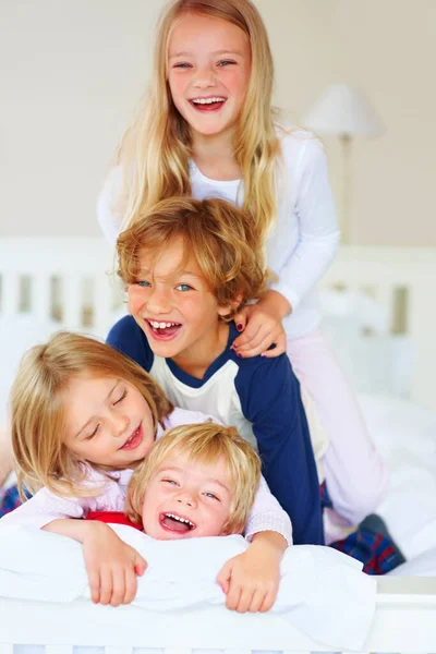 楽しい小さな兄弟姉妹が一緒にベッドで遊んでいます 喜びの弟と姉妹の肖像画一緒にベッドでプレイ — ストック写真
