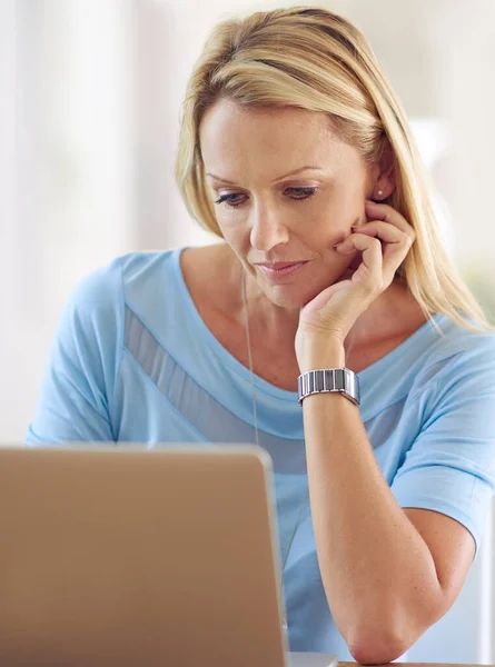 stock image Shes totally engrossed. a mature woman using a laptop at home