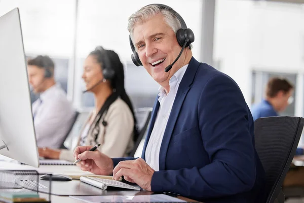 Portrait, laughing and man in call center in office working on customer service in workplace. Telemarketing, mature person and funny sales agent, consultant and telemarketer writing information
