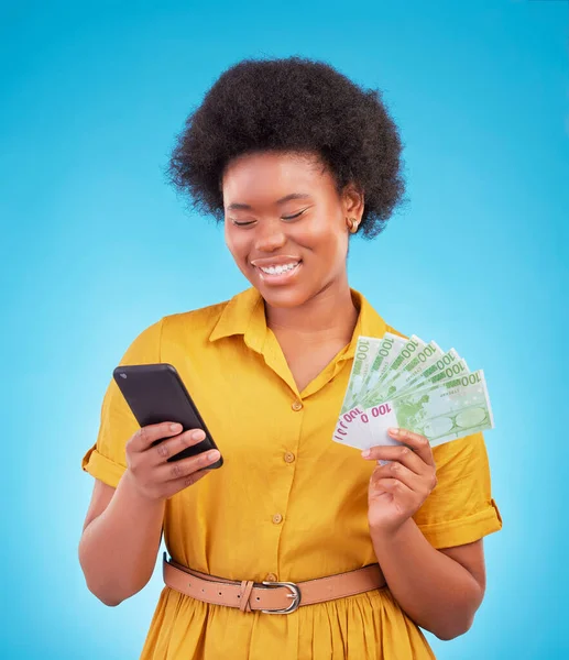 Black woman, phone and money fan with smile, winning and finance goal in studio by blue background. Girl, smartphone and cash in hand from online casino, gambling or esports app on social media chat.