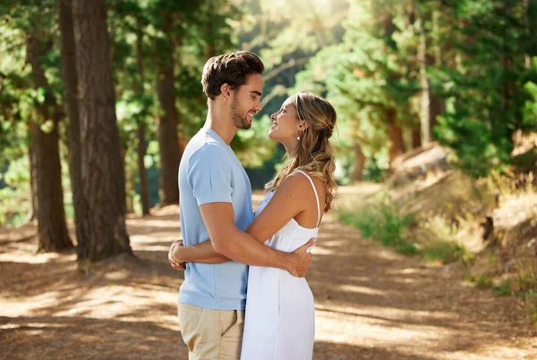 婚約発表への愛を示す若者の幸せなカップル 抱擁と屋外の森の道 女性と男性の森と木とケア一緒に自然の中で笑顔と幸福 — ストック写真