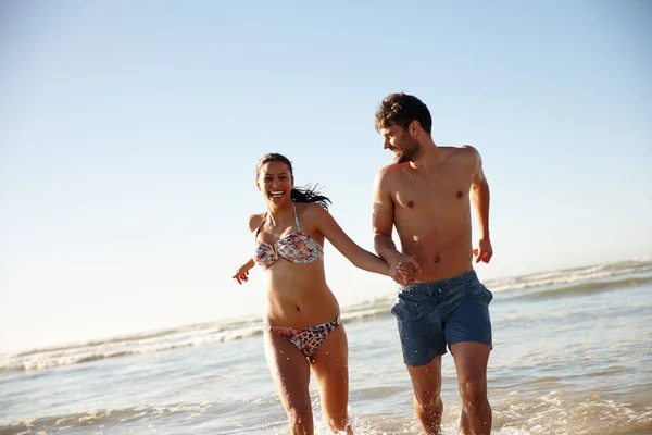 让夏天的感觉 一对年轻夫妇手牵手从海里跑出来 — 图库照片