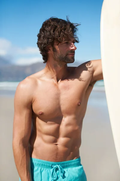 ビーチで一日 サーフボードの横に立っている若い男が — ストック写真