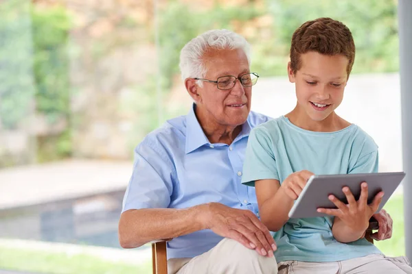 Büyükbabalar en iyisidir. Büyükbabasıyla dijital tablet kullanan bir çocuk.