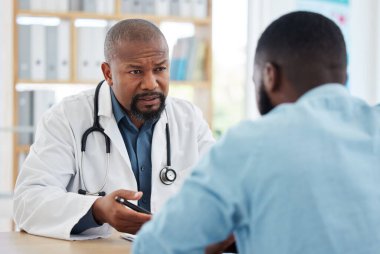 Doktor, hastanede ciddi bir siyah adam ve hasta muayenesi var. Konuşmak, muayene etmek veya sonuç almak için. Sağlık hizmetleri, tıbbi profesyonel ve Afrikalı kişi danışmanlığı veya kanser teşhisi.