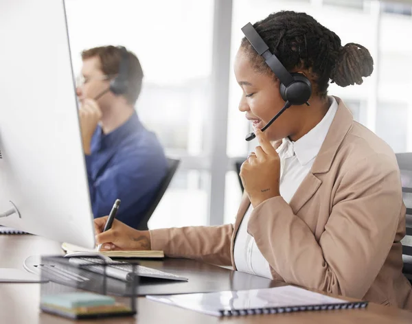 Black woman, call center and writing notes, smile in office and working on customer service in workplace. Telemarketing, notebook and happy person, female sales agent or consultant talking online