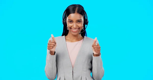 Call center, portrait or happy woman with thumbs up in studio for agreement on blue background. Smile, mockup space or Indian girl with like, success or yes hand sign at telecom crm customer services.