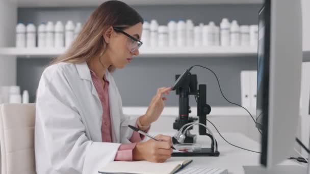 Ciência Microscópio Computador Com Uma Mulher Escrevendo Notas Enquanto Trabalhava — Vídeo de Stock
