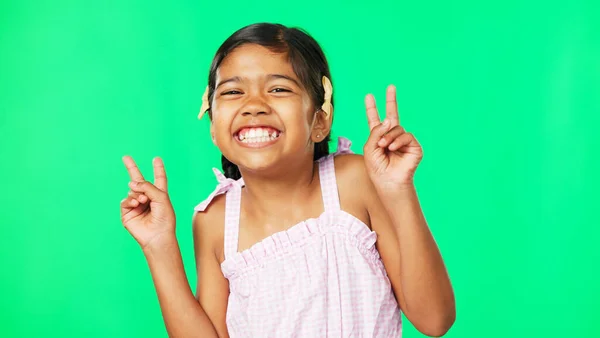 Children, peace and the portrait of a girl on a green screen background in studio with a hand gesture. Kids, happy or emoji with an adorable and playful little female child on chromakey mockup.