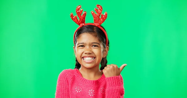 Χριστούγεννα Πράσινη Οθόνη Και Ένα Κορίτσι Κέρατα Ταράνδου Που Δείχνει — Φωτογραφία Αρχείου