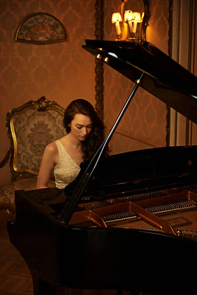 Music is the food of the soul. a beautiful young woman playing the piano
