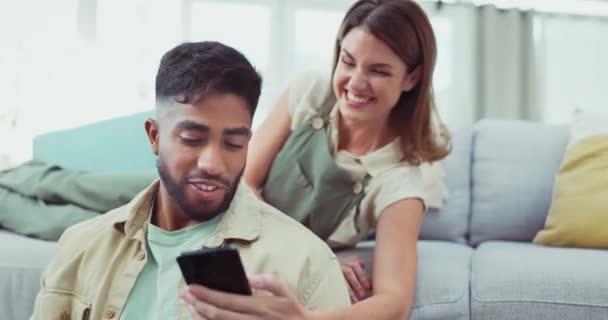 幸せなカップルはソファでリラックスし 彼らの家でソーシャルメディアミームを笑ったり共有したりします おかしいです 冗談と女性と男は愚かなテキストのためのスマートフォンをチェックします リビングルームでのアプリやメッセージ — ストック動画
