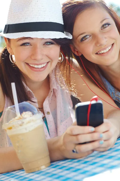 Sharing Songs Smoothies Two Adolescent Girls Sharing Earphones While Listening — Stock Photo, Image