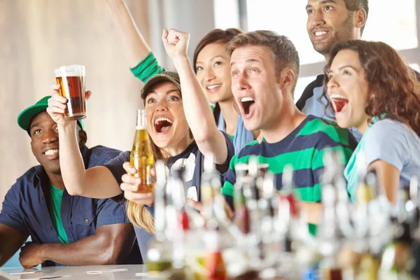 スポーツは人々を結びつける バーでお気に入りのチームを応援している興奮した友人のグループ — ストック写真