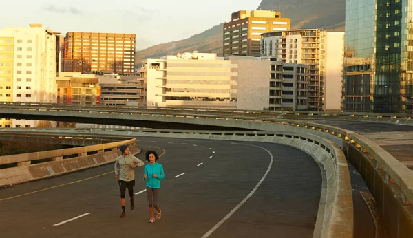 Running through the quiet urban landscape. joggers running down an empty highway in the morning