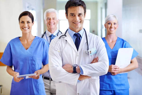准备好接下一个案子一个微笑的医疗队站在医院走廊上的画像 — 图库照片