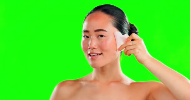 背景のモックアップに隔離されたスタジオで緑の画面上の石で顔 美しさのスキンケアと女性 皮膚科 マッサージ 肌の治療のためのローズクォーツグアシャと幸せなアジアの女性モデル — ストック動画
